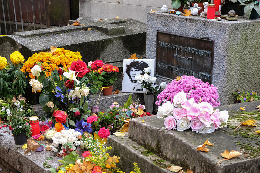 Paris, France - November 2017: Jim Morrison grave in Pere-Lachaise cemetery, Paris. Each year thousands fans and curious visitors come to pay homage to Jim Morrison's grave. Pere Lachaise is World's most visited cemetery, attracting thousands of visitors to graves of those who have enhanced French life over past 200 years. Paris, France