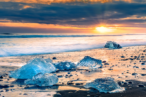 Drifting ice blocks on Diamond beach, at sunset, in Jokulsarlon, Iceland