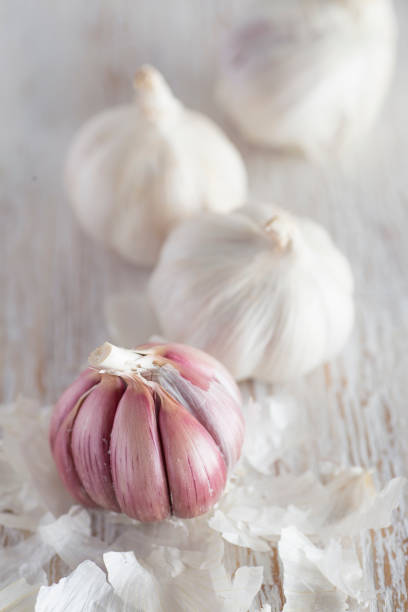 istock Group of garlics on white wood. Close-up 938218974