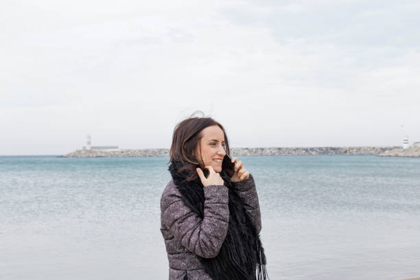 istock Beautiful woman speaking  smartphone on  the beach 938223242