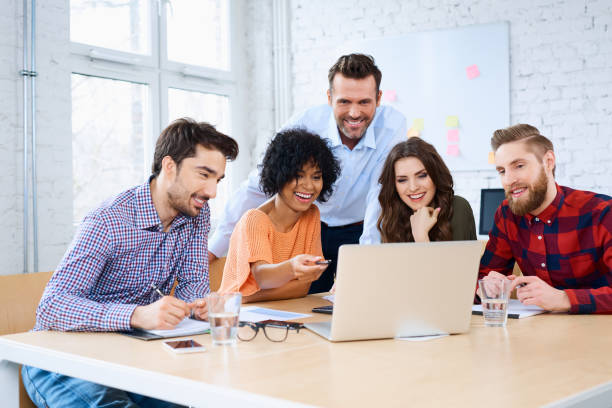 istock Happy students discussing with teacher in classroom 938226020