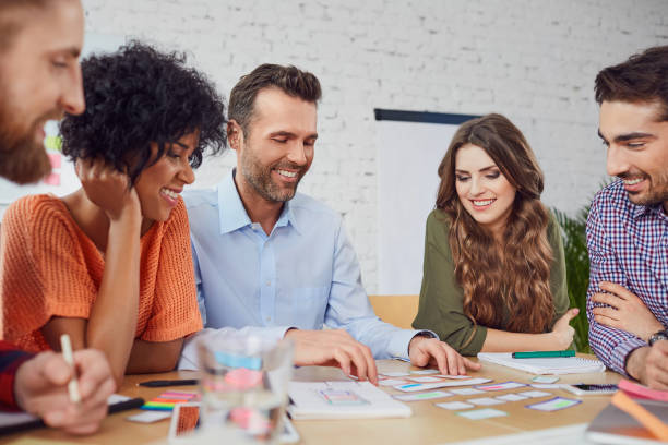 Happy web designers developing new web site layout in office Happy web designers developing new web site layout in the office teachers meeting stock pictures, royalty-free photos & images