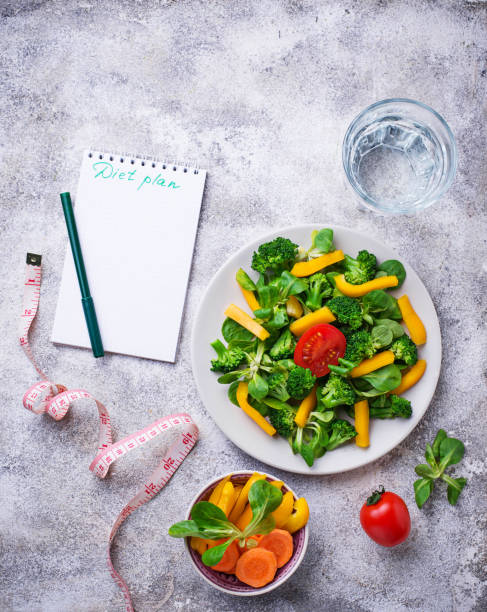 istock Healthy vegetable salad, water and measuring tape 938241848