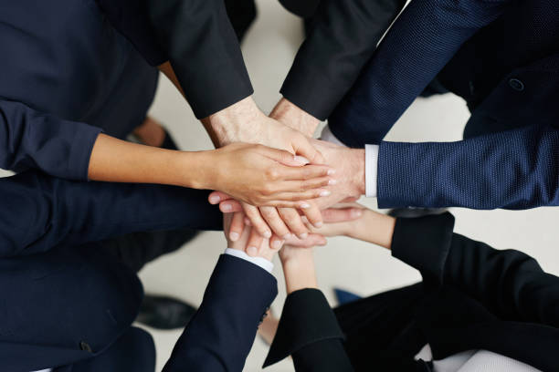 istock Group of businesspeople joining hands 938243278