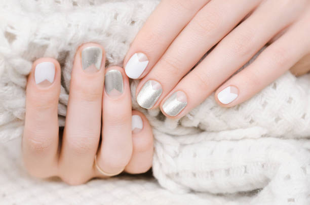 istock Female hands with white and silver nail design 938246952