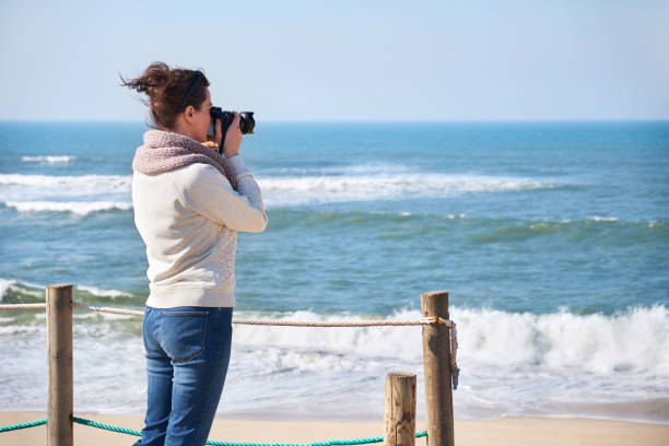 istock Young woman taking photos at a beach 938251448