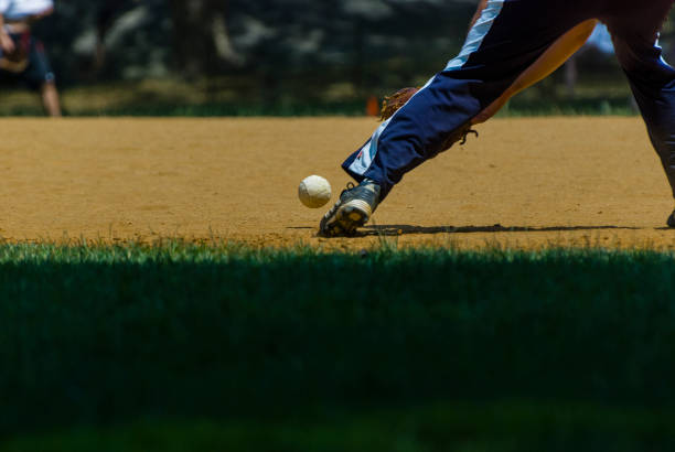 Bouncing ball Ball bouncing near a player’s foot during a softball game on a field in central park. New York, NY, United States, July 12, 2010. baseball pitcher baseball player baseball diamond stock pictures, royalty-free photos & images