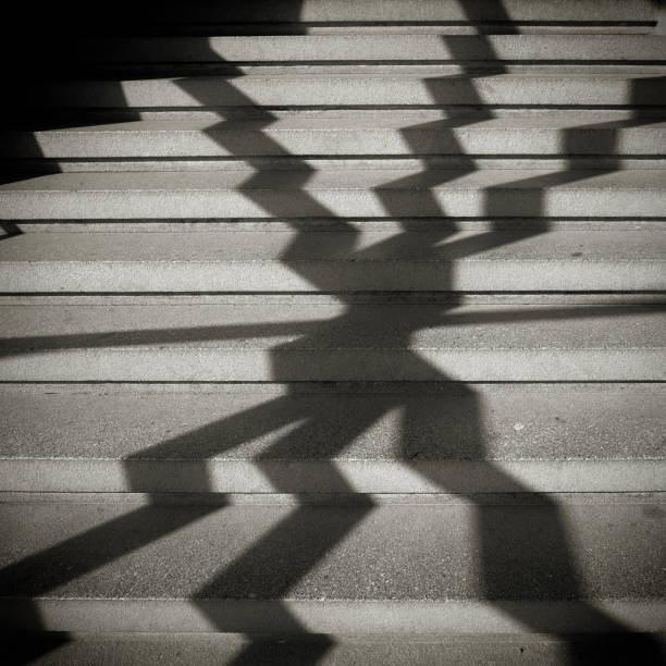 istock Shadow of a window grille on the steps of a staircase 938253976