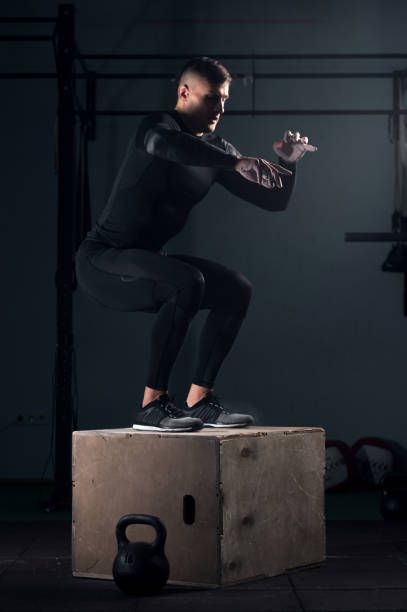 istock Strong man doing box jumps at the gym 938254666