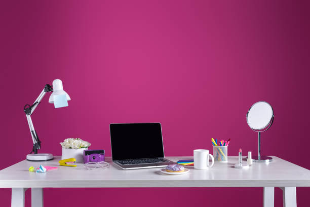 istock laptop with blank screen, doughnut with coffee, camera, cosmetics and office supplies on pink 938254936