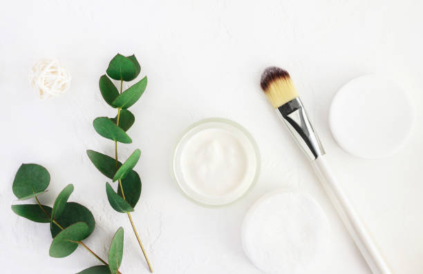 Skincare cosmetics with aroma eucalyptus plant extract. Home spa and body care. Jar of organic beauty product and application brush with fresh green leaves herbal bough, top view white background. make up brush photos stock pictures, royalty-free photos & images