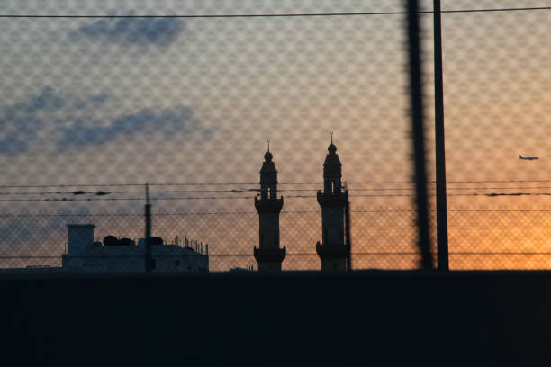 istock Red sunset with sun and silhouette of mosque minaret 938255586