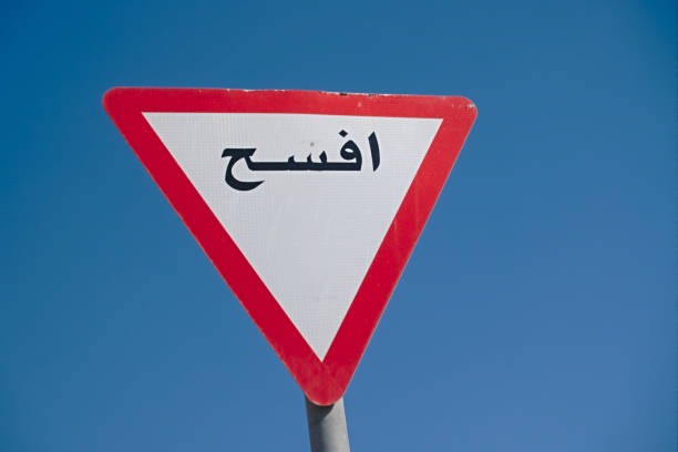 Road sign indicating give way, with international symbol and written in Arabic. Doha, Qatar