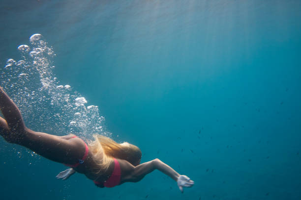 istock Female model diving to the sea floor 938265536
