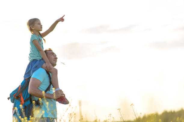 istock Cheerful man playing with daughter on grassland 938265540
