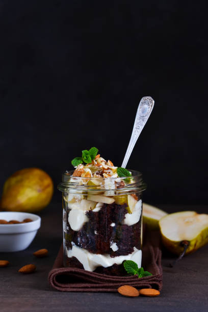 istock Creamy dessert with chocolate biscuit, caramel pear and almonds. 938269286