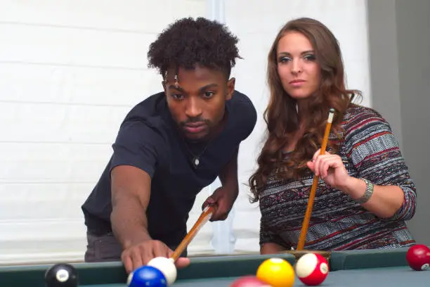 young man and women playing pool billiards fun activity recreation bar ball game