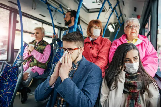 People using public transportation every day. Multi ethnic group of people of all ages use public bus for commuting. People wearing facial masks against diseases and flu.