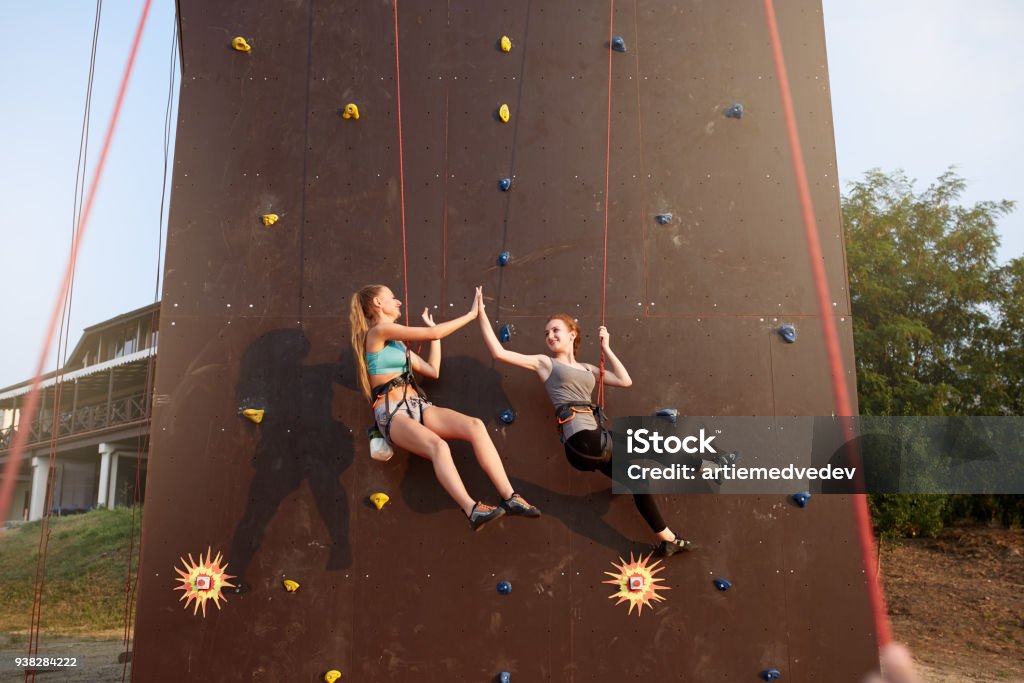 Girl On High Ropes Smiling Girls Giving High Five Hanging On Ropes At Artificial Climbing ...