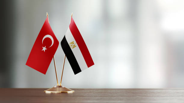 par de la bandera turca y egipcia en un escritorio sobre fondo defocused - turquia bandera fotografías e imágenes de stock