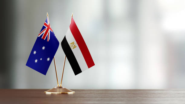 istock Australian And Egyptian Flag Pair On A Desk Over Defocused Background 938288120