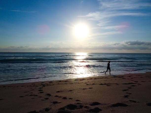 istock Woman walking on the beach 938288332