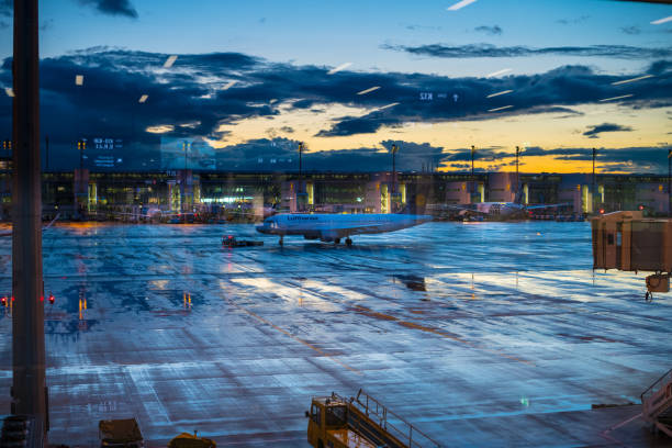 Munich, Germany - September 12, 2017: Munich airport. Large windows showing tarmac,  planes and terminal. It's the blue hour.