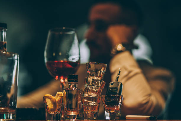 Man drinking all day One man, sitting at the bar counter alone, he has drinking problems. driving under the influence stock pictures, royalty-free photos & images