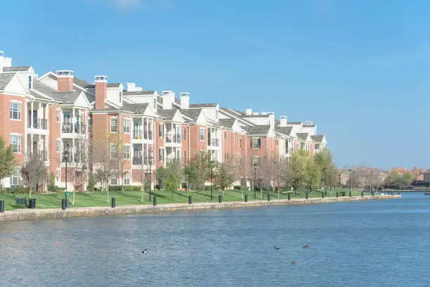 Typical lakeside apartment building complex at Las Colinas, Irving, Texas. Cloud blue sky birds , ducks swimming in front.