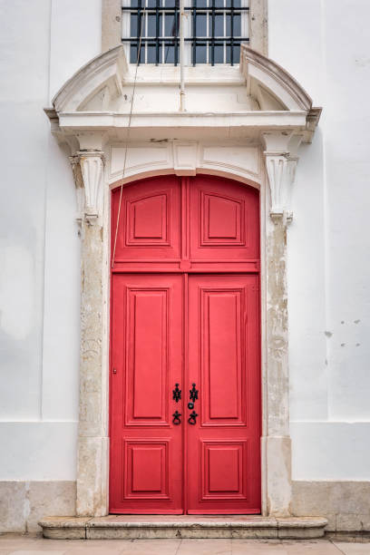 close-up door with a bright red color with black metallic accessories and keyhole