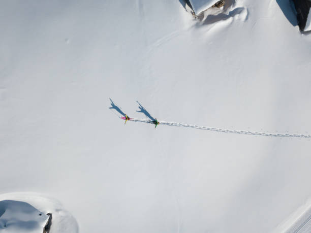 Two hikers with raised arms in deep snow from above stock photo