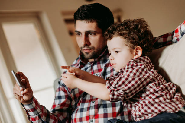 istock Father and son looking at smart phone 938307676