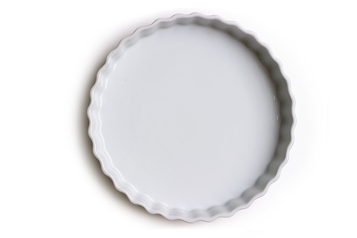 Empty ceramic tart or pie dish, on white background; with copy space