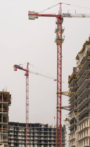 istock construction of multi-storey modern houses with cranes 938311750