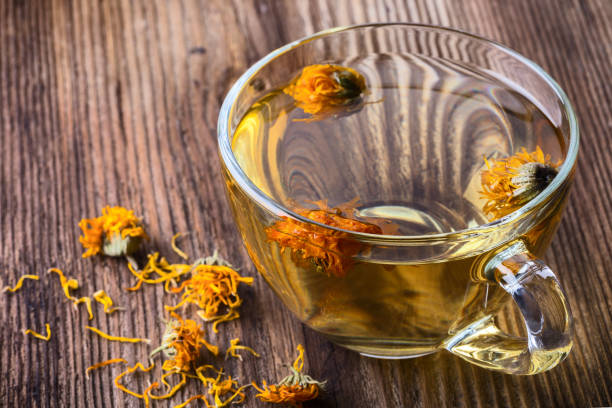 istock Calendula (Marigold) herbal tea in a transparent glass mug 938317712