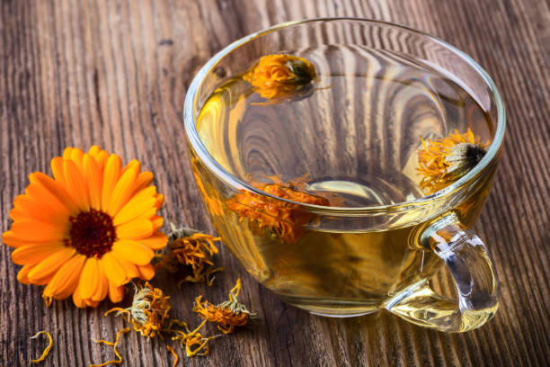 istock Calendula (Marigold) herbal tea in a transparent glass mug 938317714