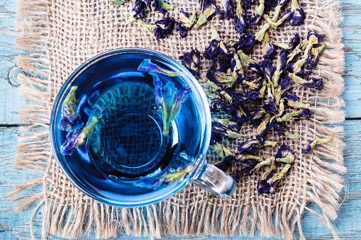 Flower tea of Butterfly pea (pea flowers, blue pea) for healthy drinking, detox drinking on old wooden table top view