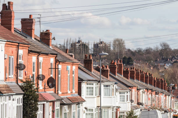 Row of terraced house roofs with chimney stacks stock photo