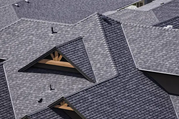 Rooftop in a newly constructed subdivision showing asphalt shingles and multiple roof lines