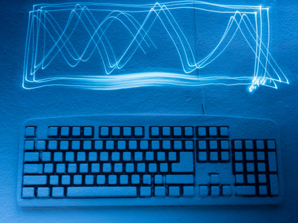 istock computer keyboard covered with snow illuminated by blue light with traces from Light painting 938333286