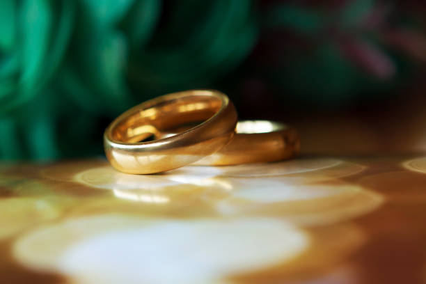 istock Two golden wedding rings on bokeh background 938337302