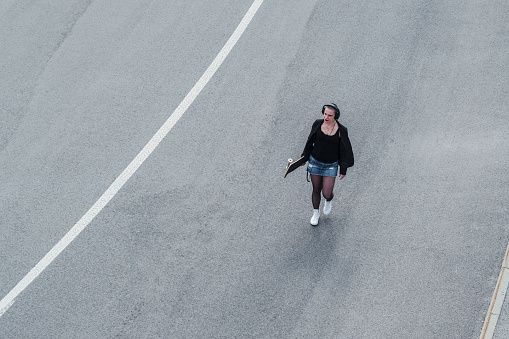 Street style woman crossing urban road.