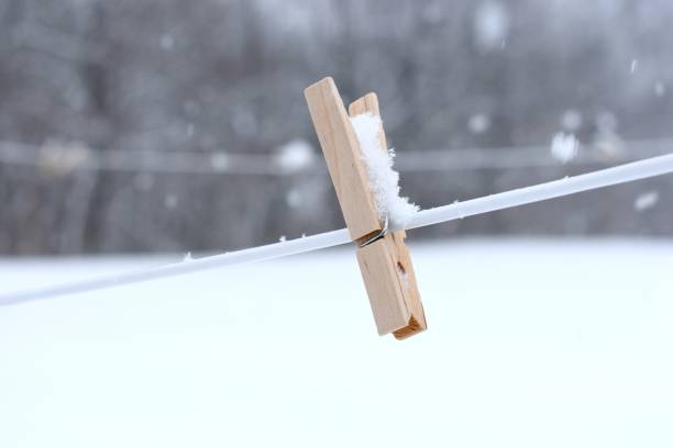 A lonely clothespin left on the clothesline and gets covered by snow.