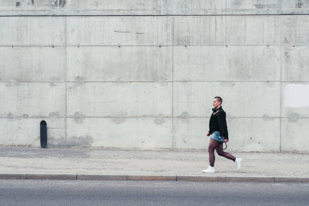 donna in stile street che cammina in città - skirt women jeans white foto e immagini stock