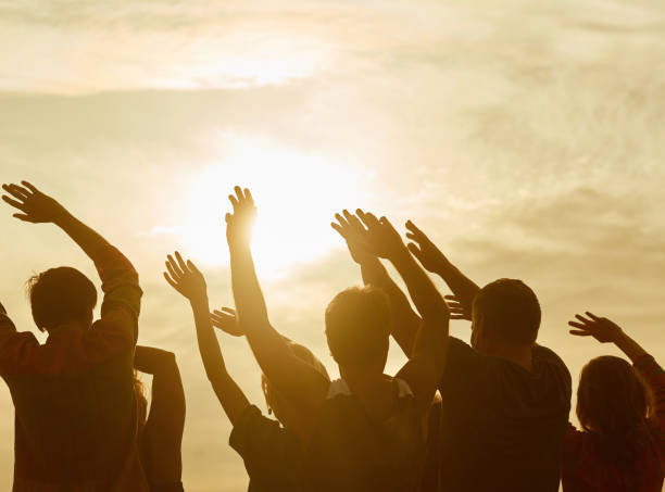 istock Silhouettes of happy people with hands up. 938340452
