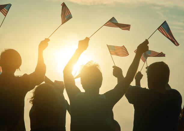 istock People raising USA flags in the air. 938340716