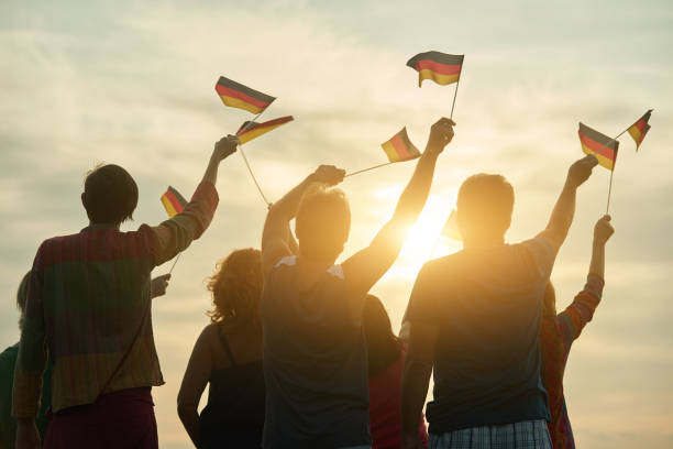 istock Crowd of people holding deutsch flag, back view. 938342950
