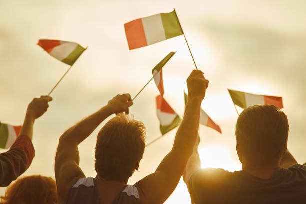 istock Young people waving italian flags, back view. 938342980