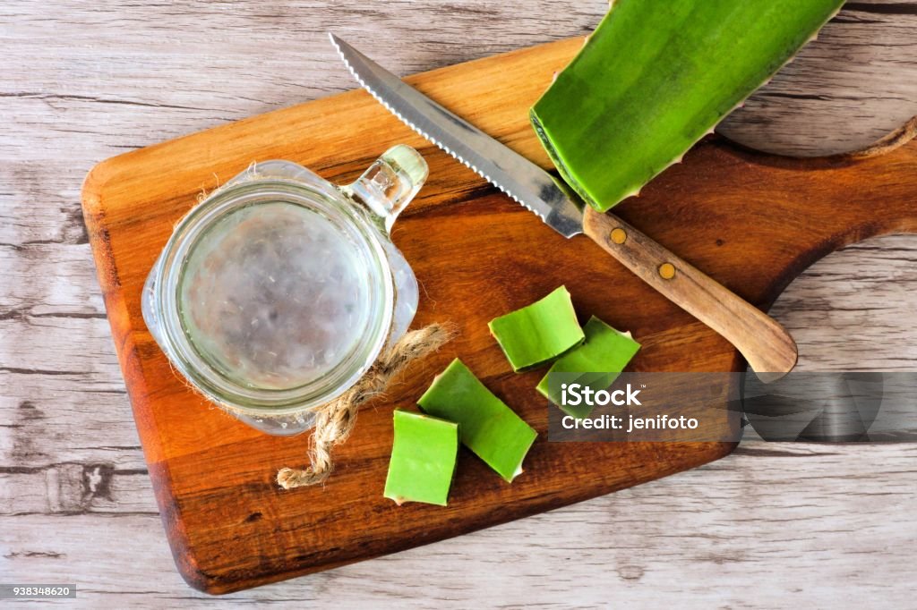 Jugo de Aloe vera en un tarro de masón. Vista superior sobre una tabla de paddle. - Foto de stock de Gel de aloe vera libre de derechos