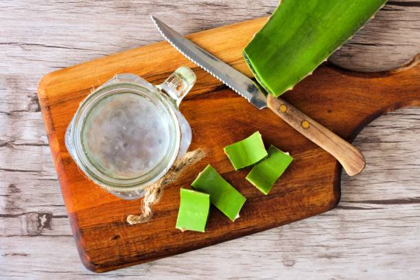 Aloe vera juice in a mason jar. Top view on a paddle board. Healthy Aloe vera juice in a mason jar glass. Top view scene on a wooden paddle board. aloe juice stock pictures, royalty-free photos & images